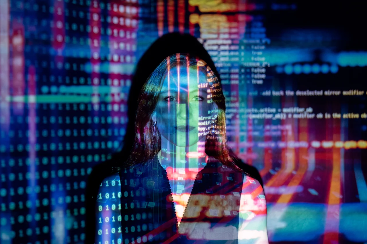 A woman with lines of code and data projected onto her face.