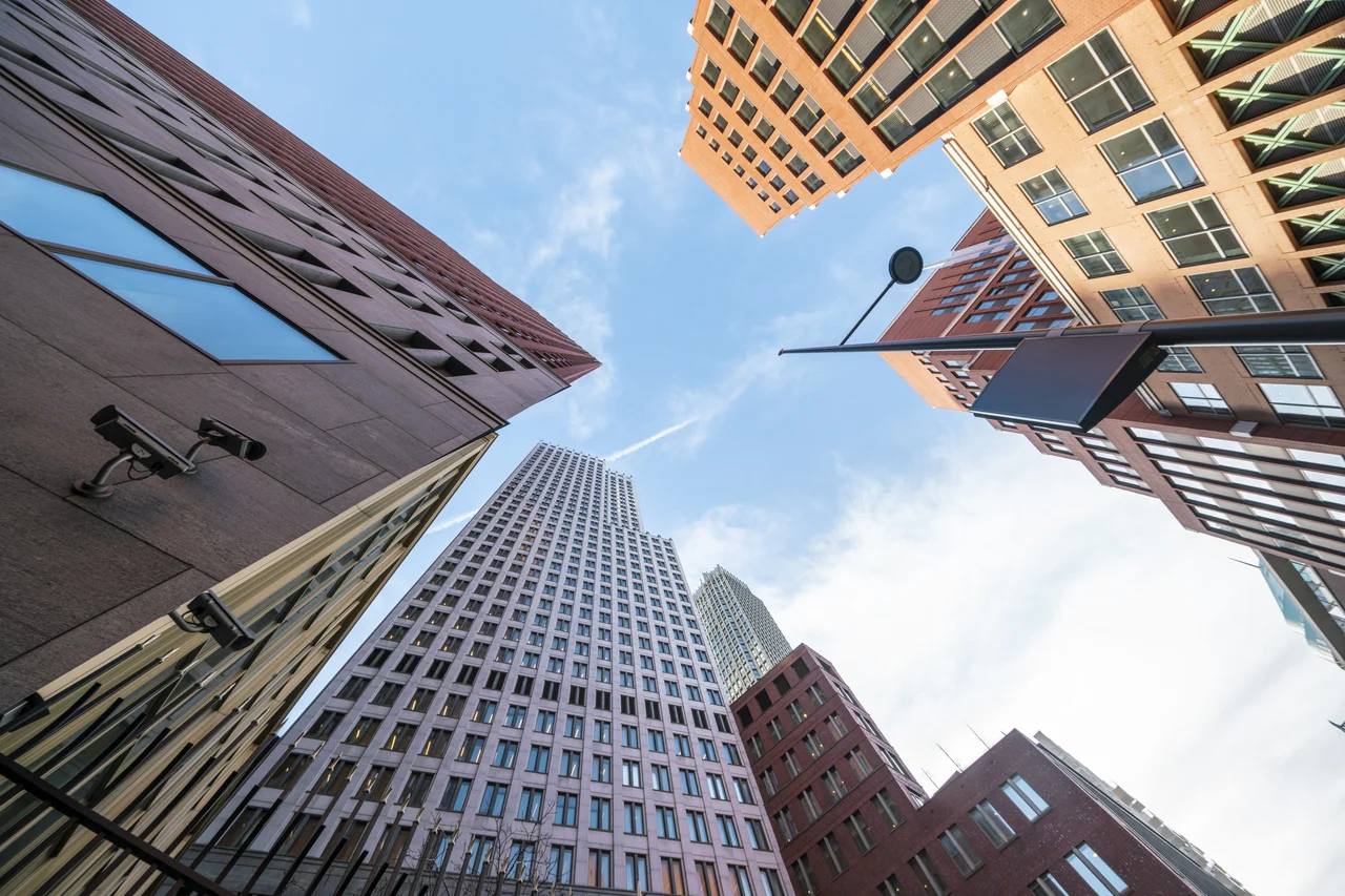 A series of tall skyscrapers set against a blue sky shot from the ground.