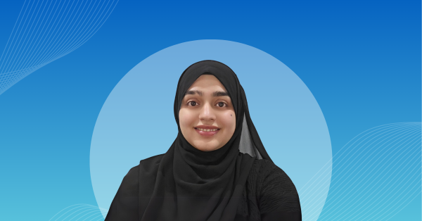 Faiza Qazi in front of a blue background.
