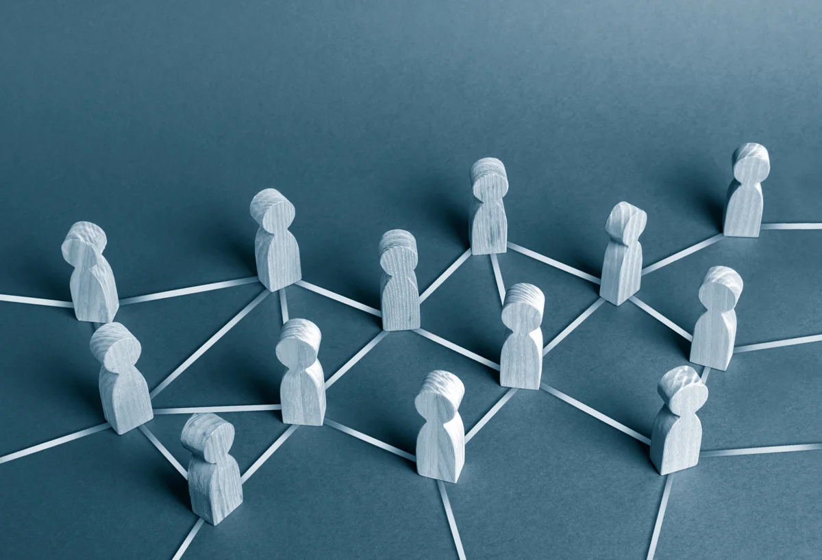 A series of human cut-outs with threads connecting them.