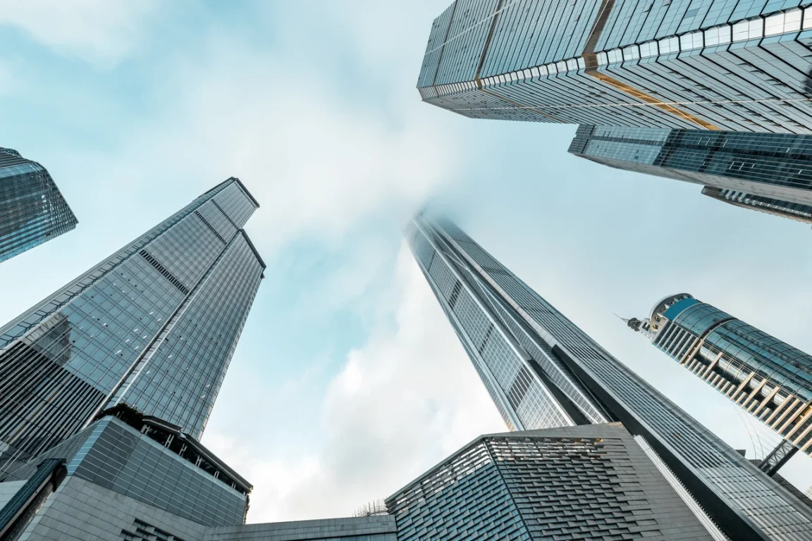 Office buildings against a moody, cloudy sky.