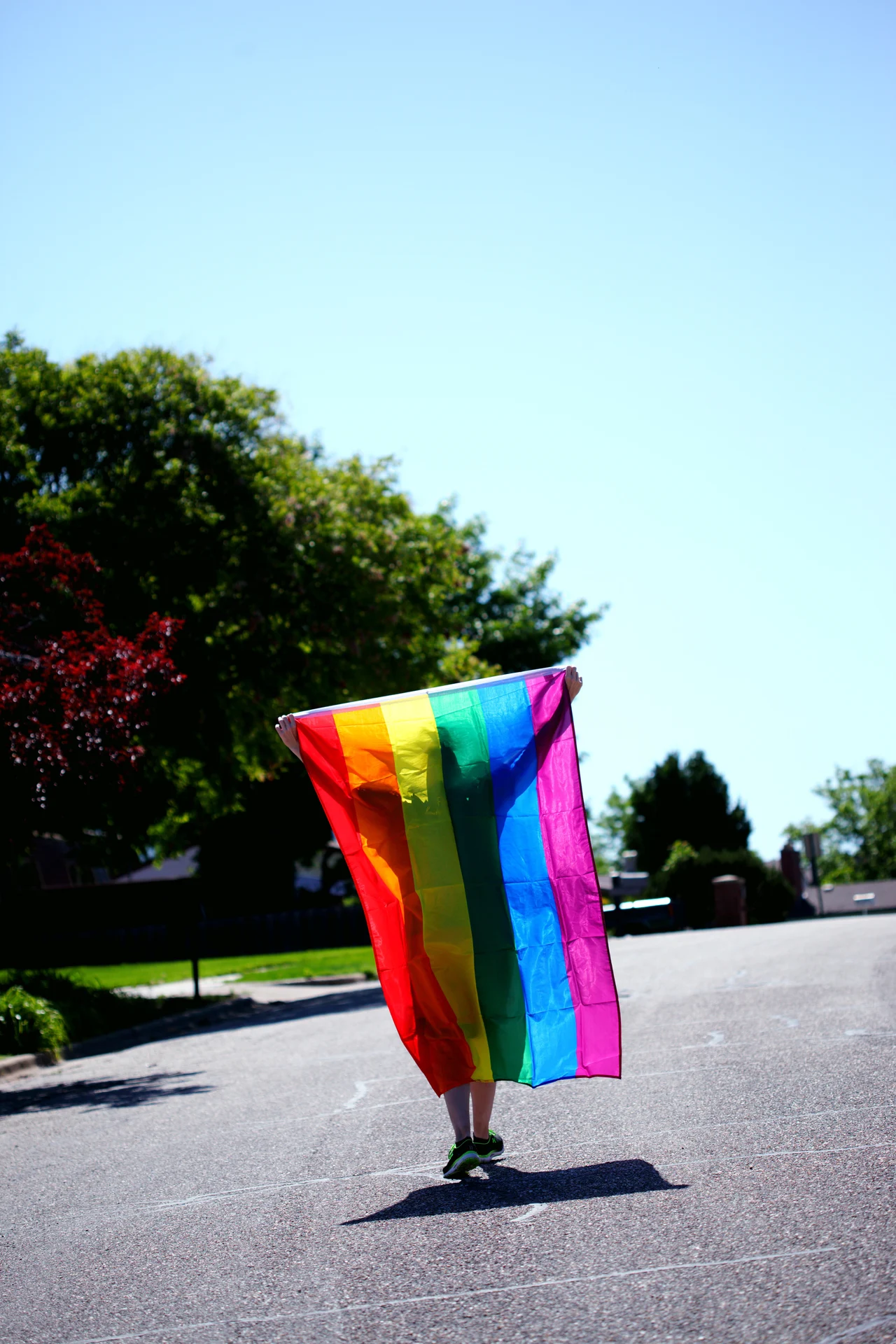 A person running with the LGBTQIA+ flag.