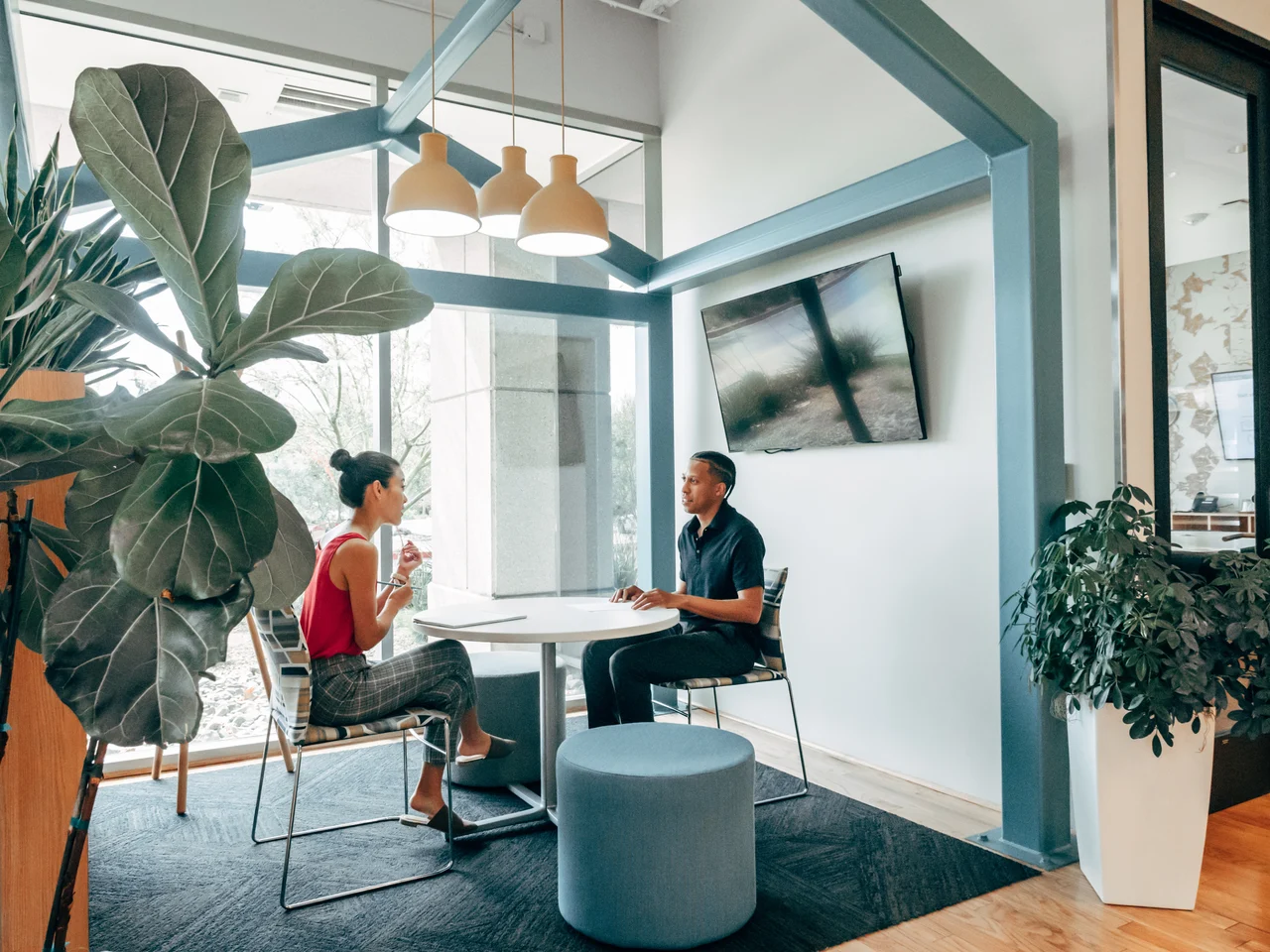Two colleagues sitting having a chat in a modern office space.