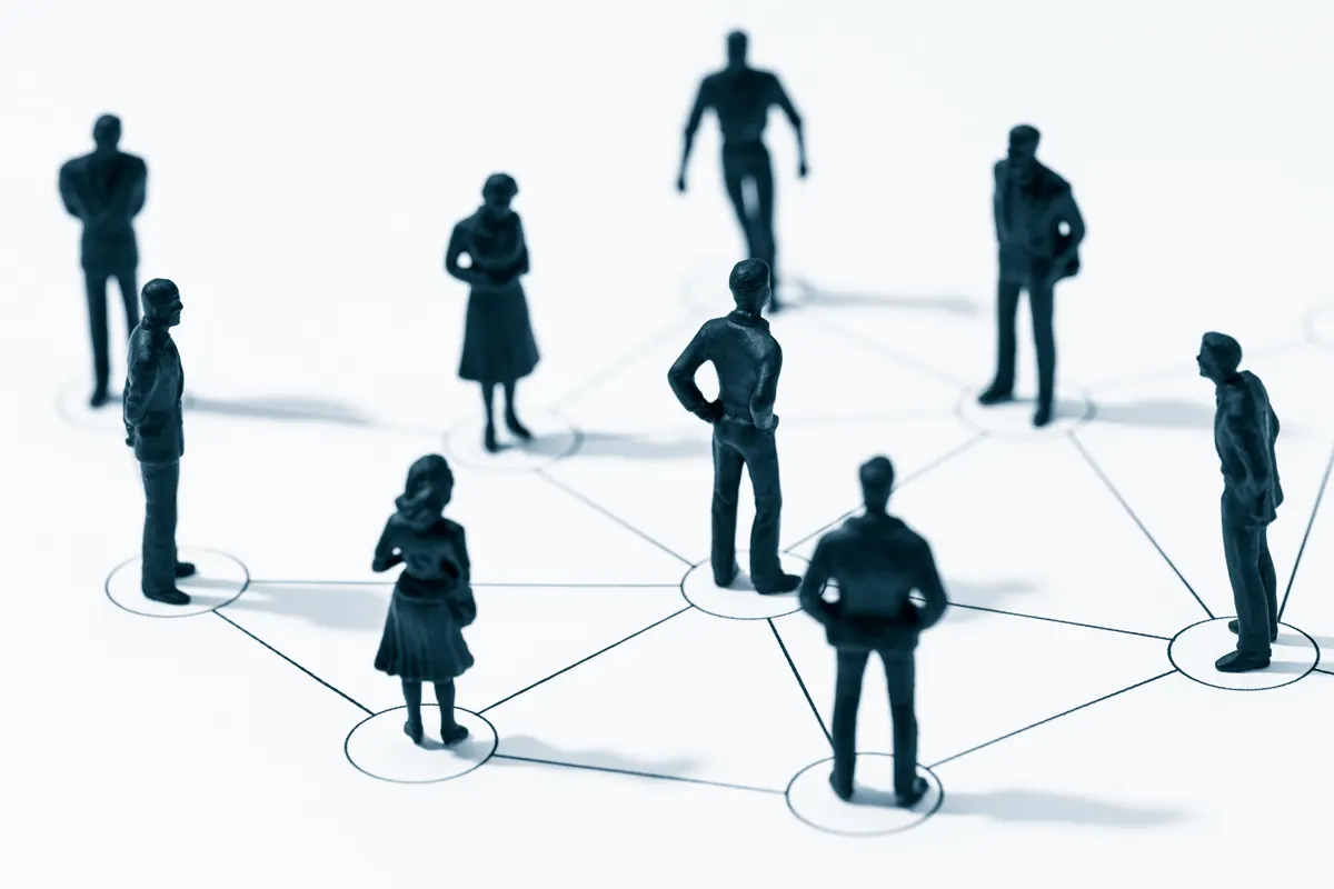 Miniature people connected with lines.