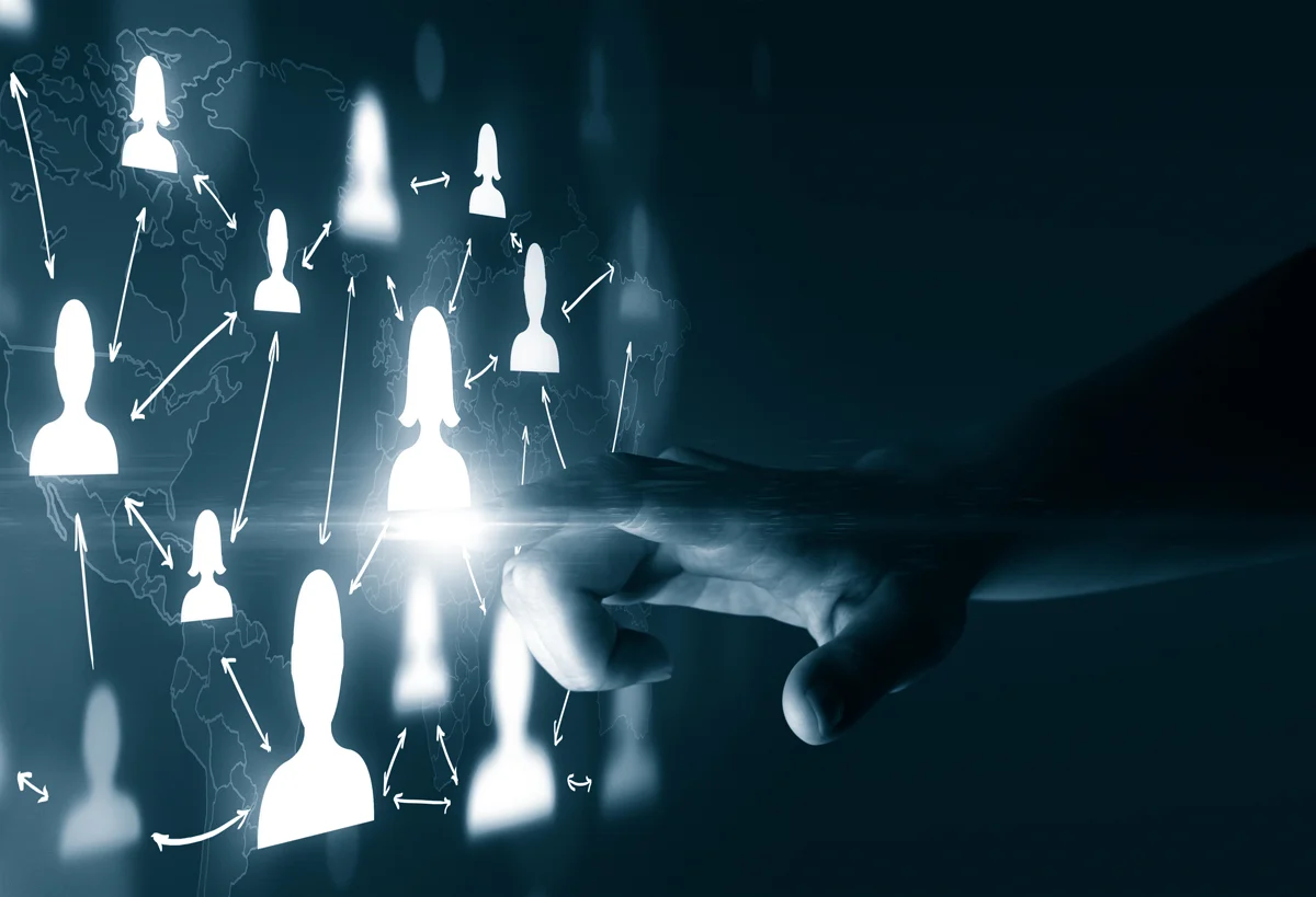 A person touching a wall with people icons on it.